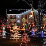 colorful christmas lights on a front lawn at night. Get black friday christmas decorations this November!