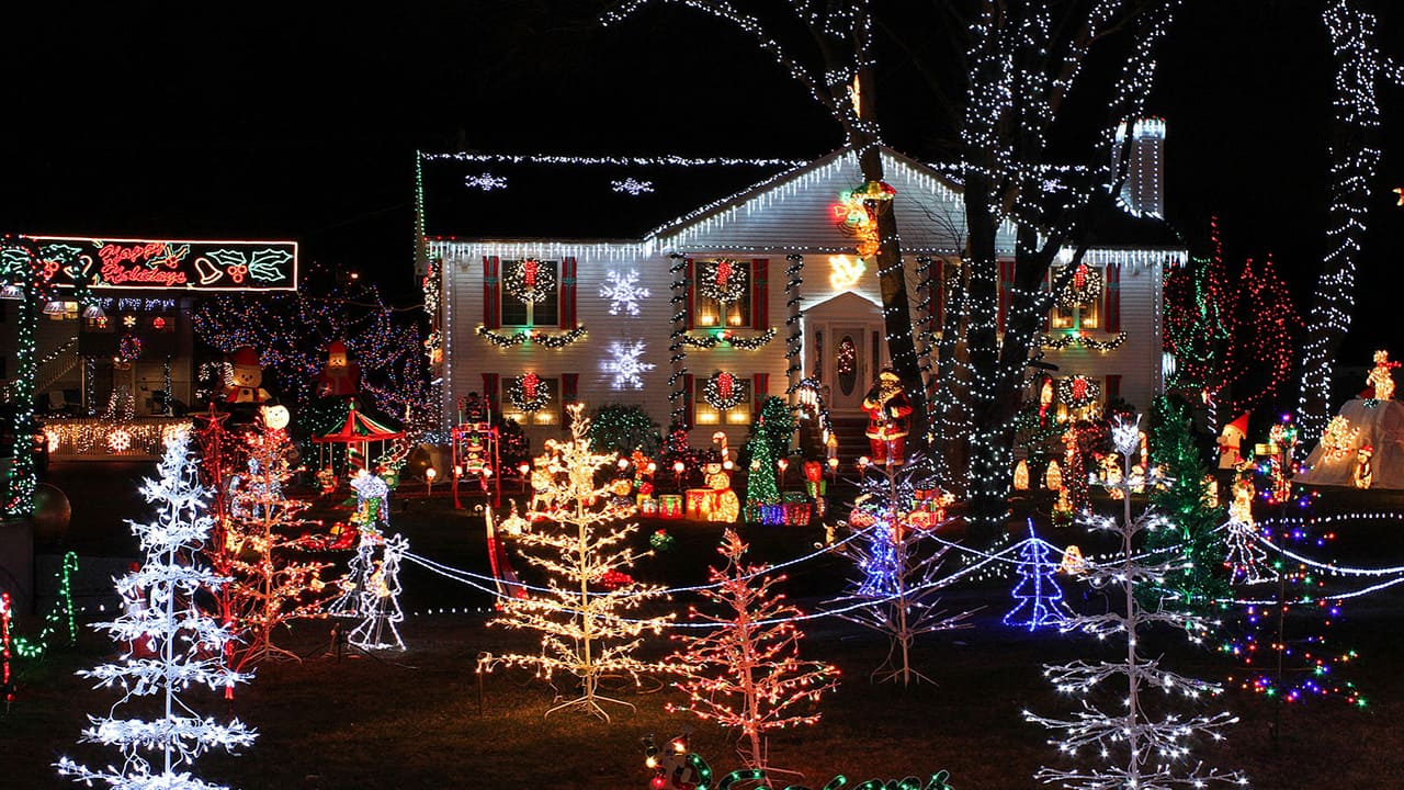 colorful christmas lights on a front lawn at night. Get black friday christmas decorations this November!