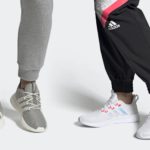 Two models from the knee down show off adidas pants and shoes.