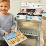 boy playing with toy kitchen set